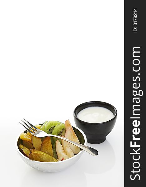 Fruits with yoghurt dip over a white background (lots of copy space)