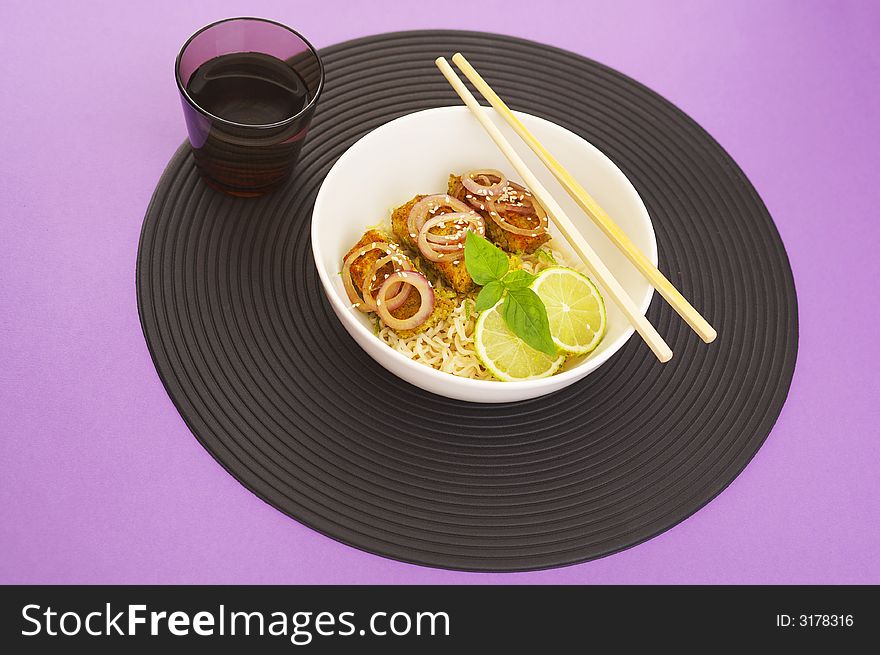 Asian style noodles and deep fried fish on purple background. Asian style noodles and deep fried fish on purple background