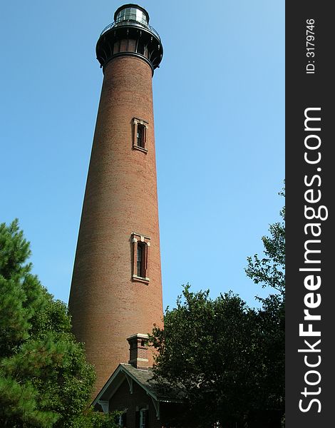 The Currituck Lighthouse on the Outer Banks in North Carolina- against a blue sky.