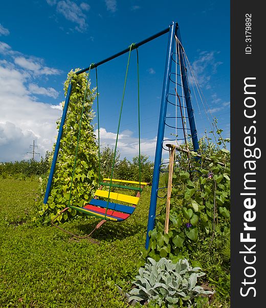 Coloured swing in a small garden. Coloured swing in a small garden