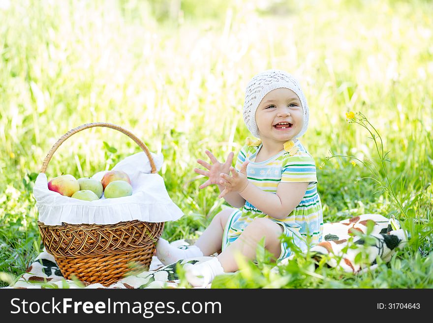 Baby eating apples from basket outdoors. Baby eating apples from basket outdoors