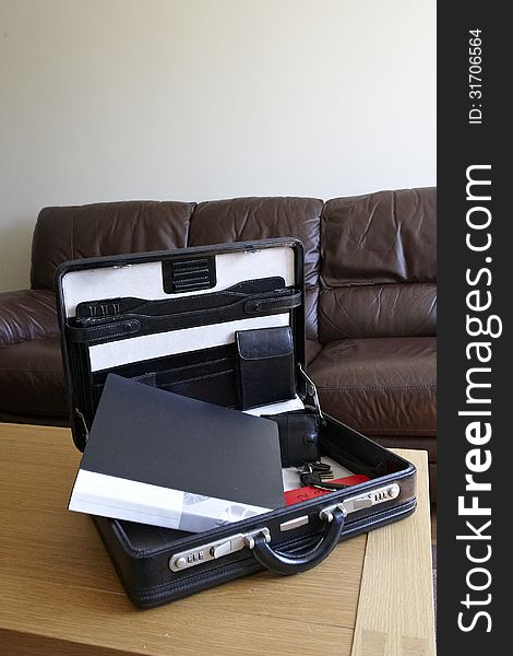 Open black briefcase with items for meeting. Open black briefcase with items for meeting