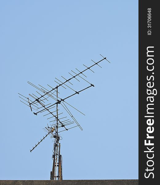 Old receiver tv antenna on top of building in daytime. Old receiver tv antenna on top of building in daytime