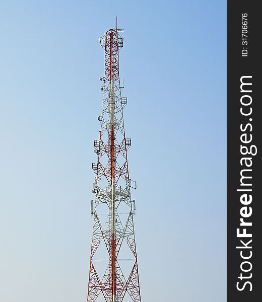 Red tower telecommunication antenna in blue sky