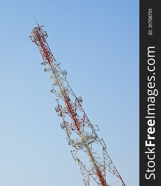 White and red tower telecommunication antenna in blue sky. White and red tower telecommunication antenna in blue sky