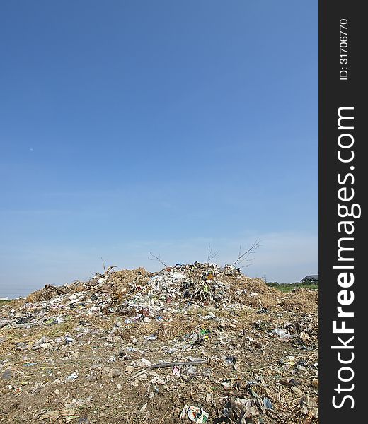 Small pile of garbage in blue sky and sunlight. Small pile of garbage in blue sky and sunlight