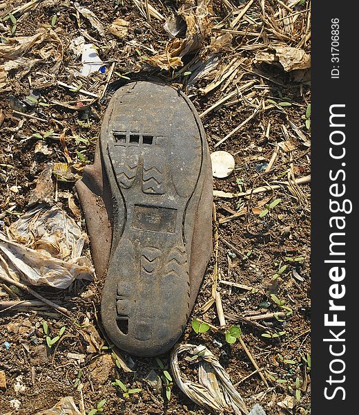 Marking sole of abandon old canvas shoes on ground