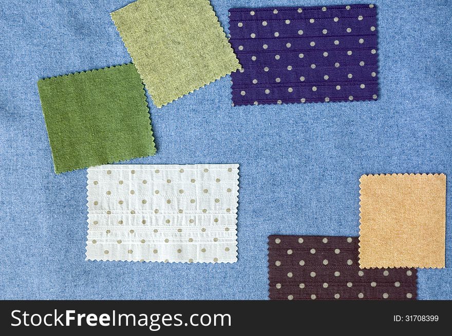 Pieces of colorful fabric on blue fabric
