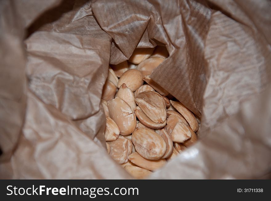 Fresh raw almonds in brown paper bag closeup. Mallorca, Balearic islands, Spain.