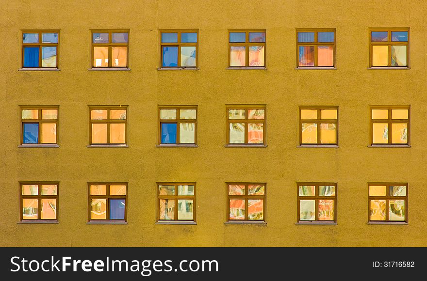 Yellow wall of an office building with blue windows