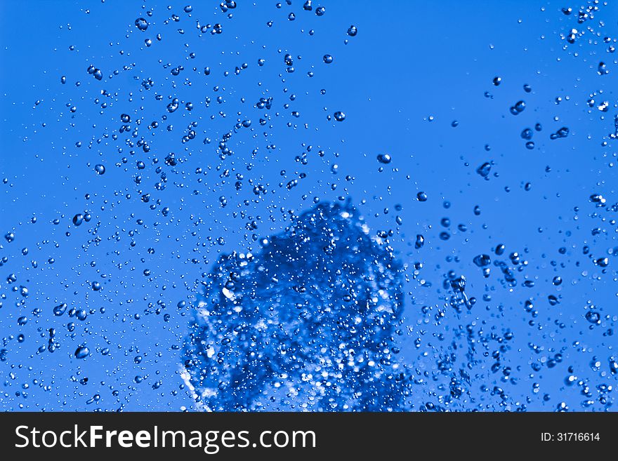 Water bursting upward splashing on a blue background. Water bursting upward splashing on a blue background
