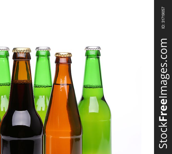 Closed bottles of beer are located left on a white background. Closed bottles of beer are located left on a white background