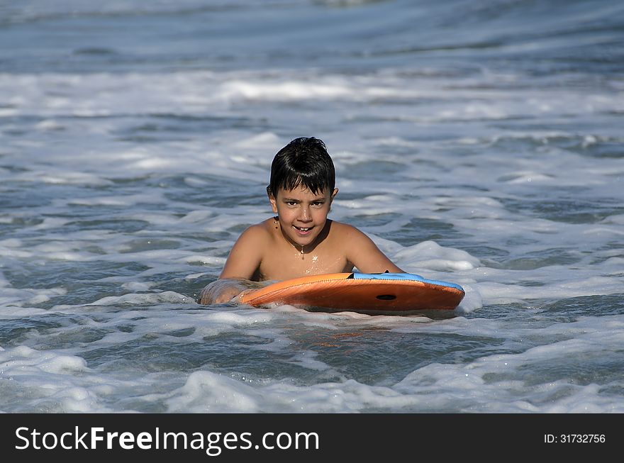 A boy with his tablet to surf on blue waves of the Mediterranean Sea. A boy with his tablet to surf on blue waves of the Mediterranean Sea