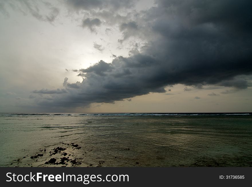 Beginning of Cloudy Sunrise over Ocean Water's Edge outdoors. Beginning of Cloudy Sunrise over Ocean Water's Edge outdoors