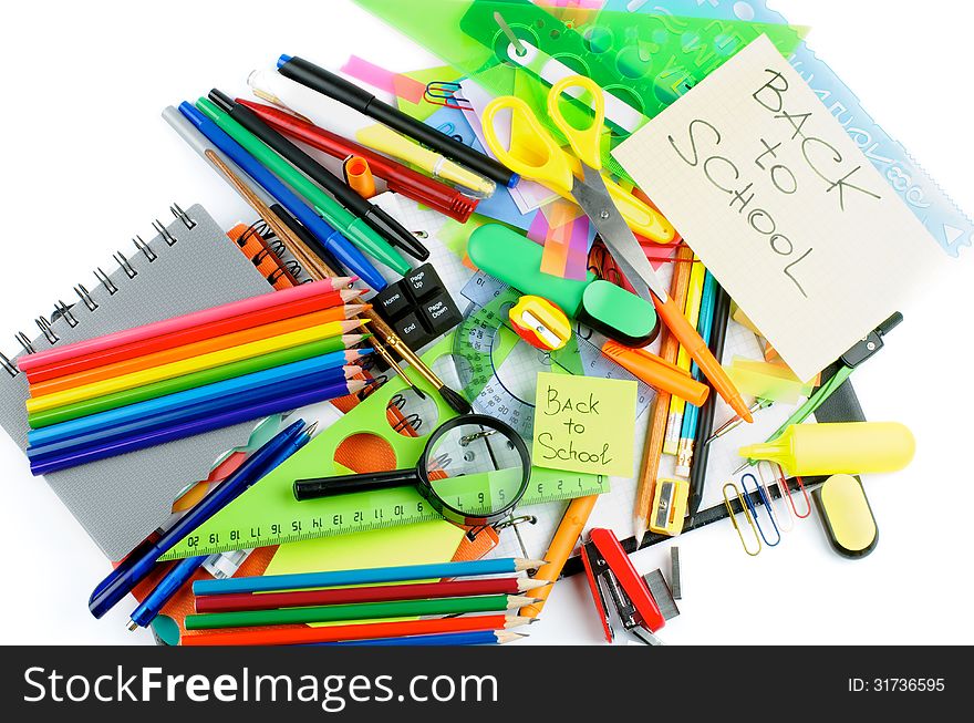 Back to School. Various Stationery Items with Pens, Pencils, Paint Brushes, Felt In Pens, Erasers and Lines on Checked Note Pad isolated on white background