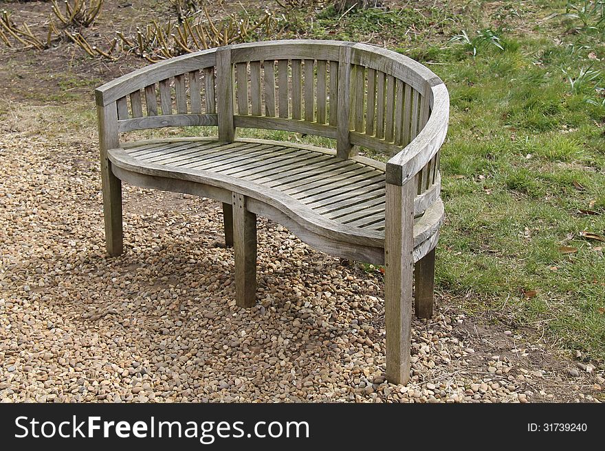 A Wooden Garden Bench with a Round Back. A Wooden Garden Bench with a Round Back.