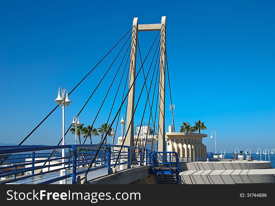 Fragment of modern urban foot-bridge on the background of the blue sky. Fragment of modern urban foot-bridge on the background of the blue sky