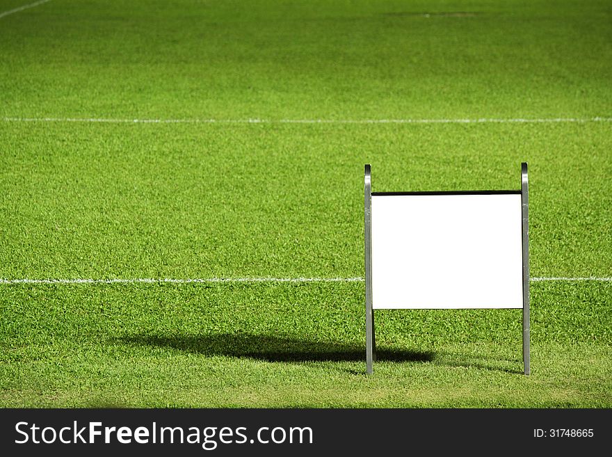 Grass field with blank notice board, really for text or photo insert.