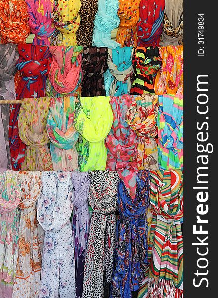 Collection of colorful shawls hanging knotted in multiple rows. Collection of colorful shawls hanging knotted in multiple rows