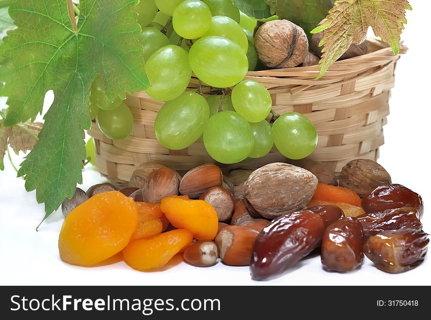 Grapes in a basket and dried fruits on white background. Grapes in a basket and dried fruits on white background