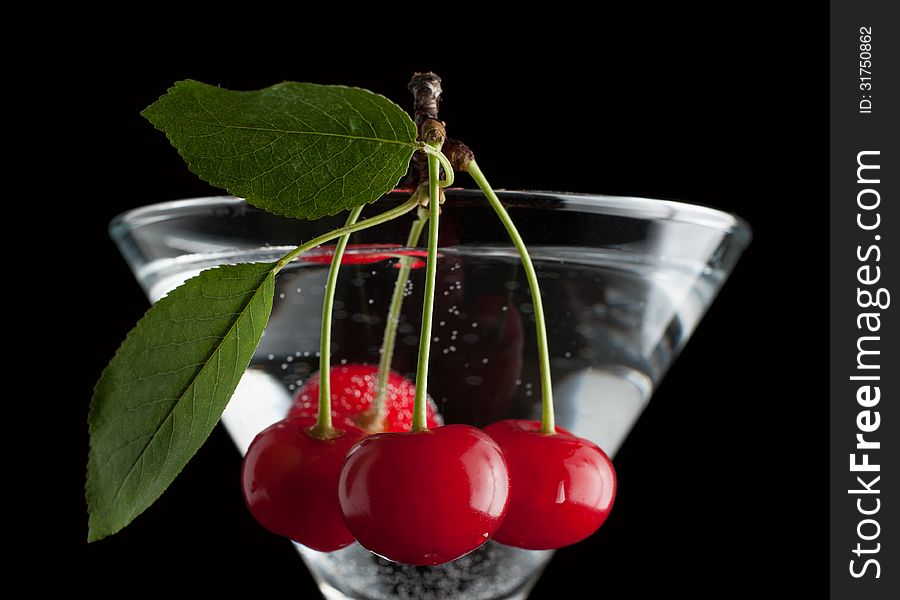 Cherries in a martini glass on black. Cherries in a martini glass on black.