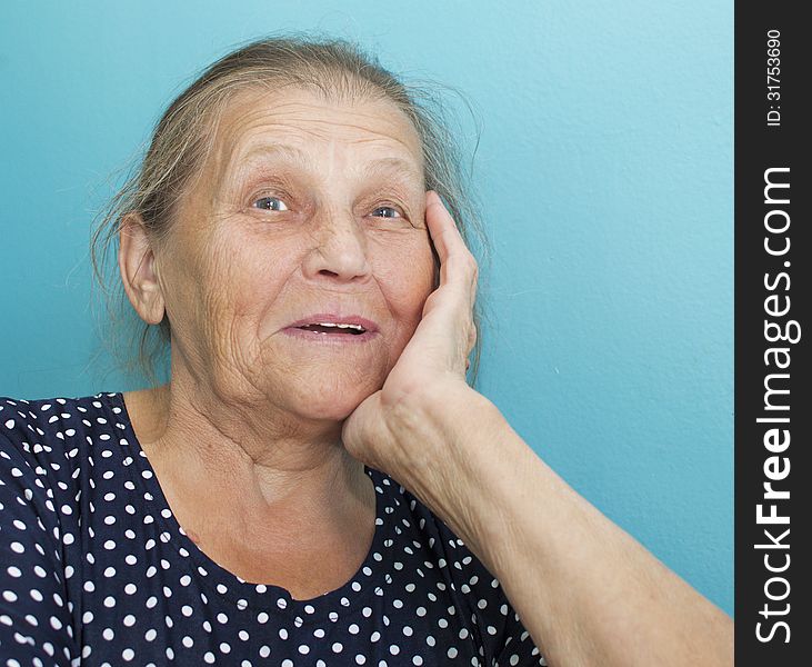 The happy elderly woman supports the head a hand and laughs. The happy elderly woman supports the head a hand and laughs.