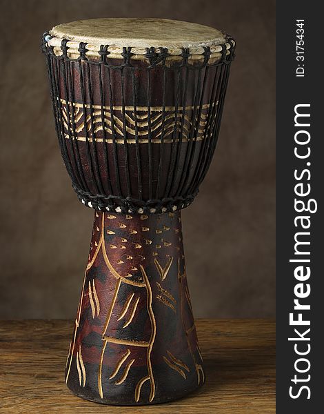 Vertical photo of african hand drum with soft diffused light brown background