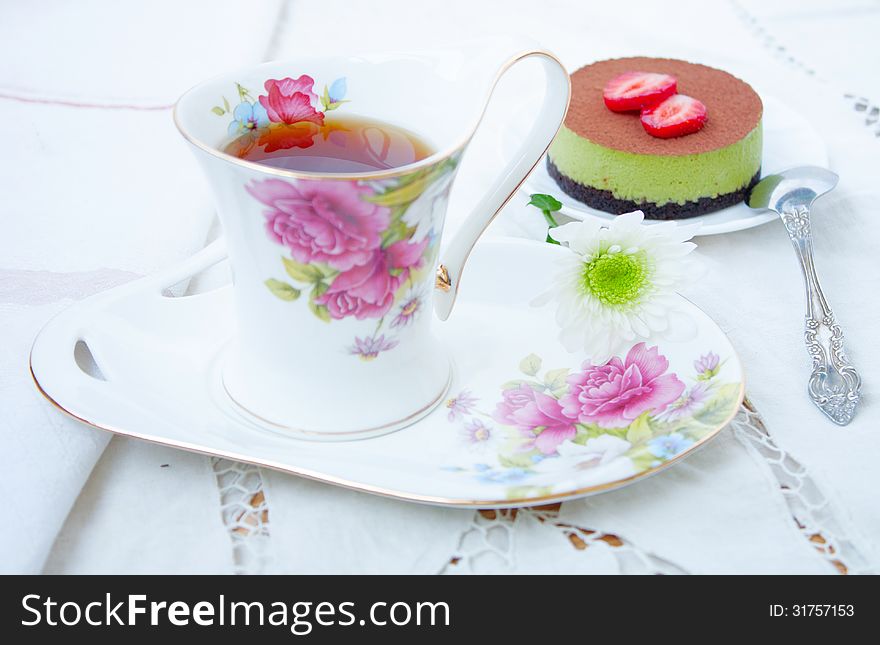 Tiramissu cake green tea with strawberries and a cup of tea. Tiramissu cake green tea with strawberries and a cup of tea