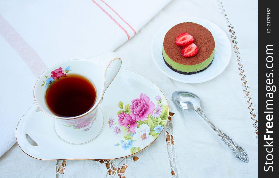 Tiramissu cake green tea with strawberries and a cup of tea. top view. Tiramissu cake green tea with strawberries and a cup of tea. top view