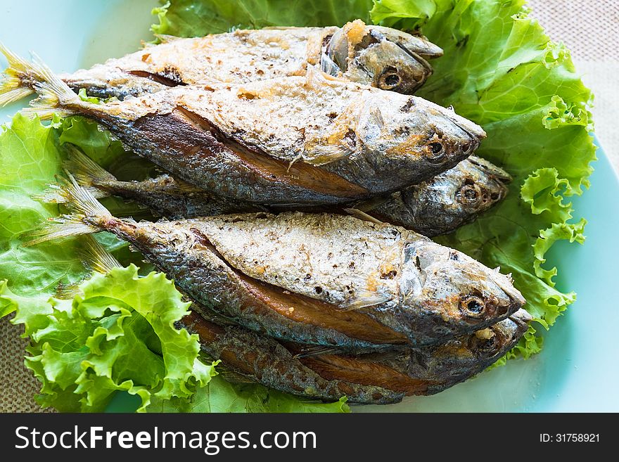 Thai local fried mackerel fish with fresh green vegetable