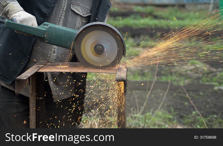 Man using a circular saw for processing metal construction