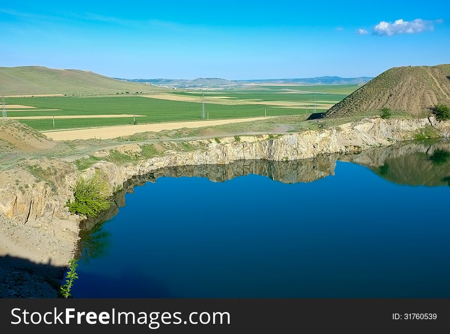 Blue lake with blue sky in reflection