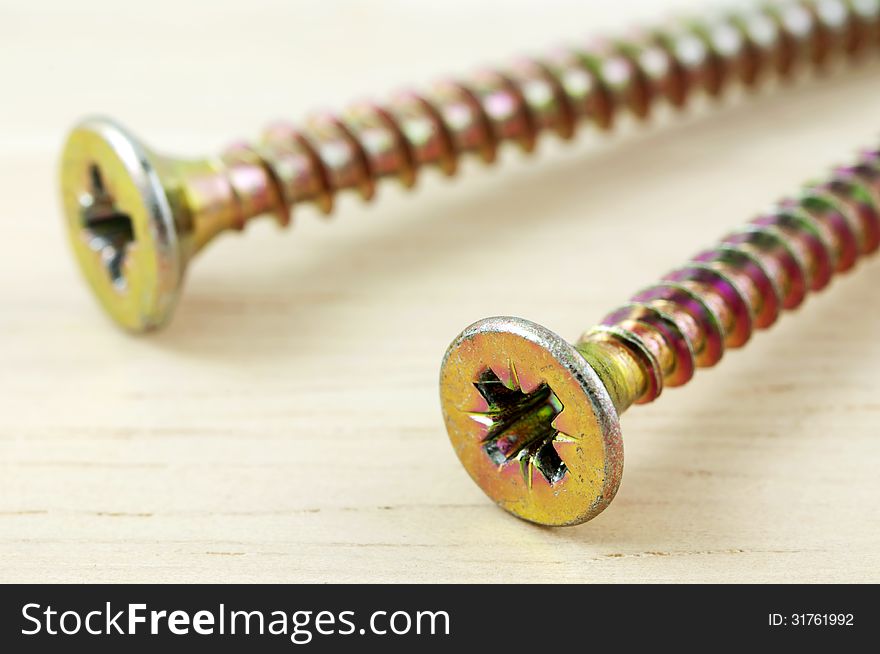 Macro photo of screws on wooden desk