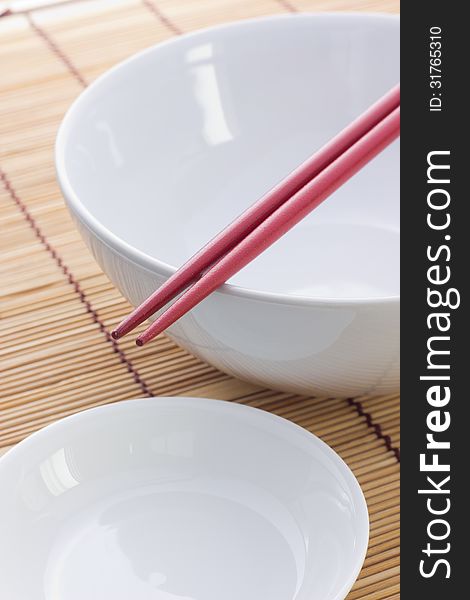 Two chopsticks next to and white bowl