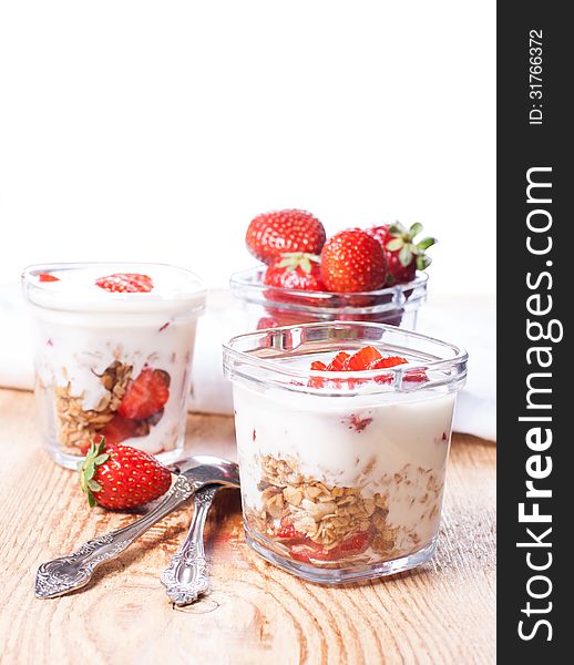 Yougrt, strawberries and granola in glass jars. Yougrt, strawberries and granola in glass jars