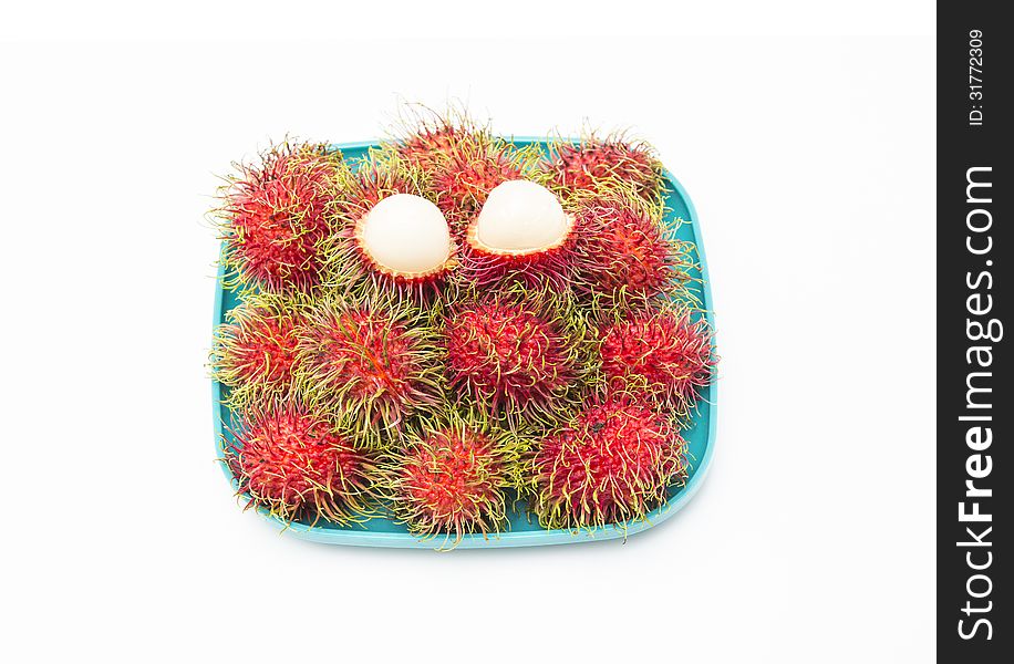 Rambutan in green dish isolated on white background.