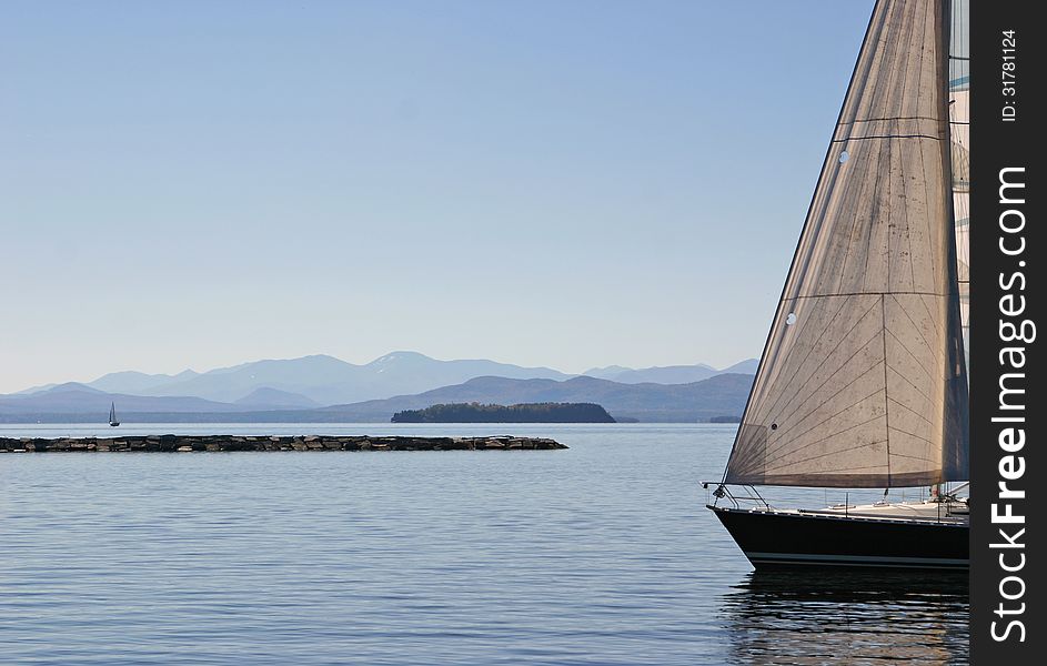 Sailboat with the mountains of Burlington, Vermont in the background. Sailboat with the mountains of Burlington, Vermont in the background.