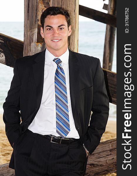 Good looking young man at the beach under the pier. Good looking young man at the beach under the pier.