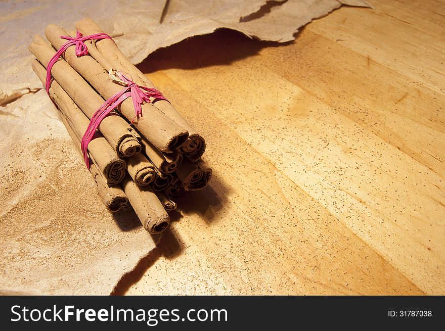 Cinnamon sticks on the wooden table. Near powder of cinnamon and packaging paper. Cinnamon sticks on the wooden table. Near powder of cinnamon and packaging paper