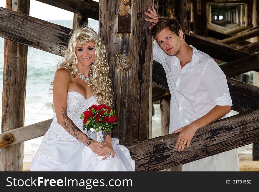 A beautiful young married couple posing at the beach. A beautiful young married couple posing at the beach.