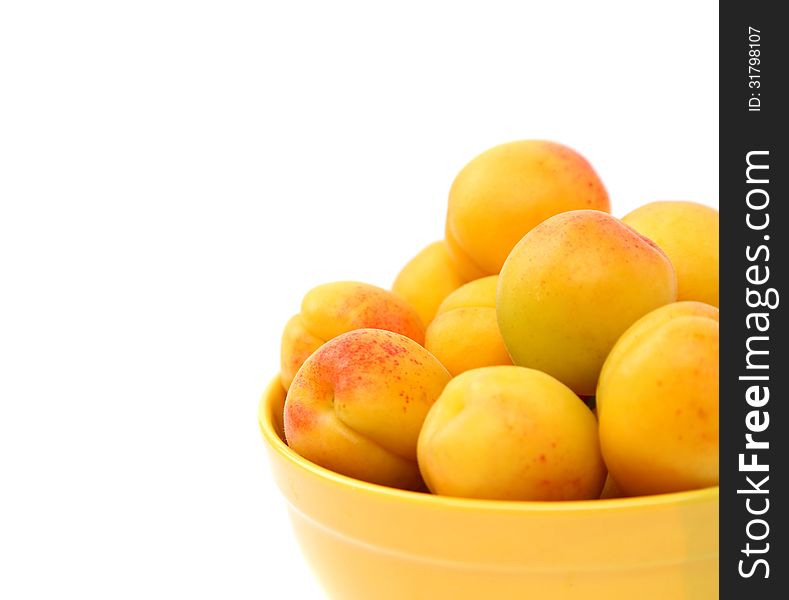 Fresh apricot on a bowl are located right on the white background