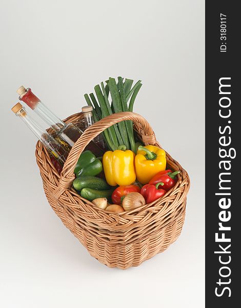 Basket with peppers, cucumbers, onions and oil. Basket with peppers, cucumbers, onions and oil