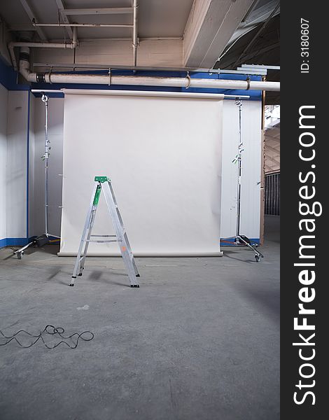 Background stand with a gray-beige paper roll inside a factory. Background stand with a gray-beige paper roll inside a factory.