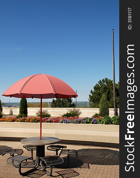 Picnic table with a bright red umbrella to provide shade. Picnic table with a bright red umbrella to provide shade