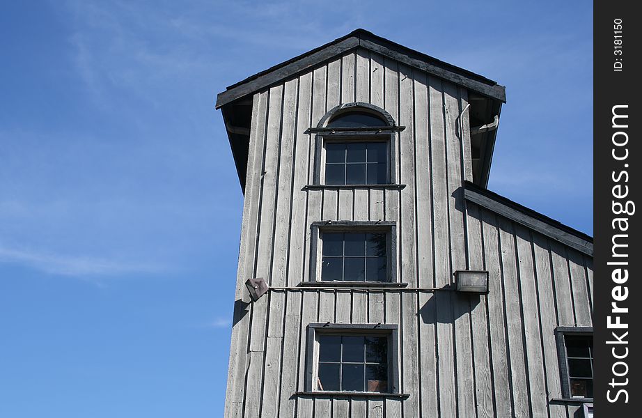 A tower of art studios rises from a gray wooden building.