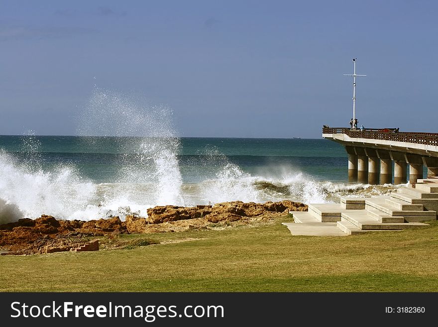 Rough seas and breaking waves next to a pier. Rough seas and breaking waves next to a pier