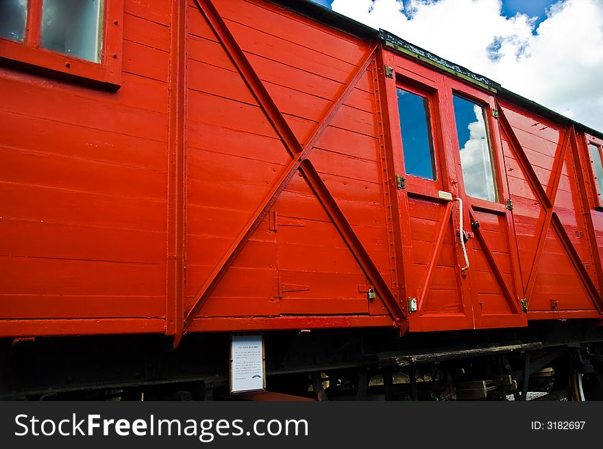 Red railway carriage with reflected blue sky