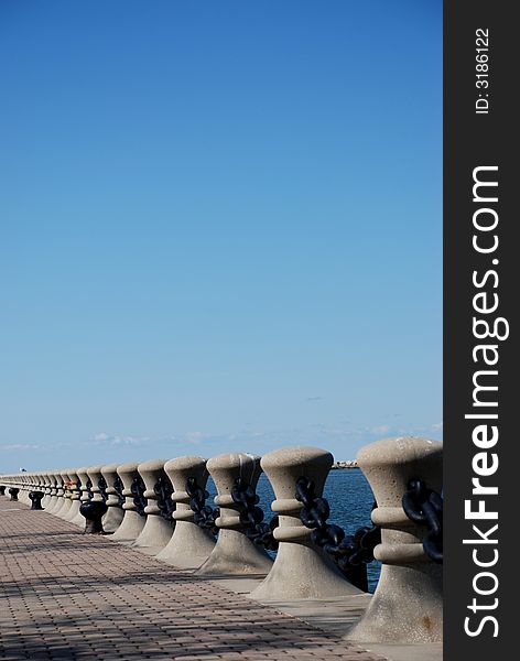 A brick walkway lined with pillars and chains. A brick walkway lined with pillars and chains