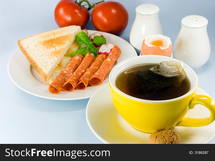 Breakfast with red tea,boiled egg and sausage