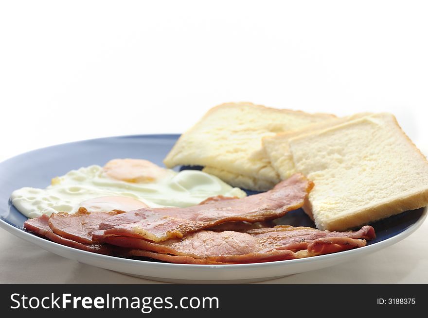 An image of bacon egg with bread and butter on a blue plate. An image of bacon egg with bread and butter on a blue plate